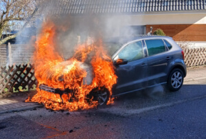 Ein Auto, bei dem aus dem Motorraum Flammen schlagen.